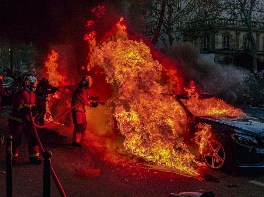 Intense photo of firefighters extinguishing a blazing car fire on the streets of Paris.
