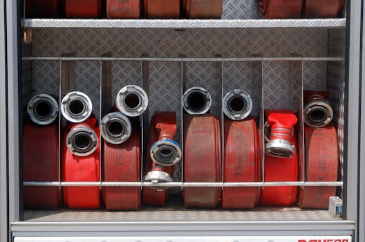 Close-up of firefighting hoses stored neatly in a firetruck compartment.
